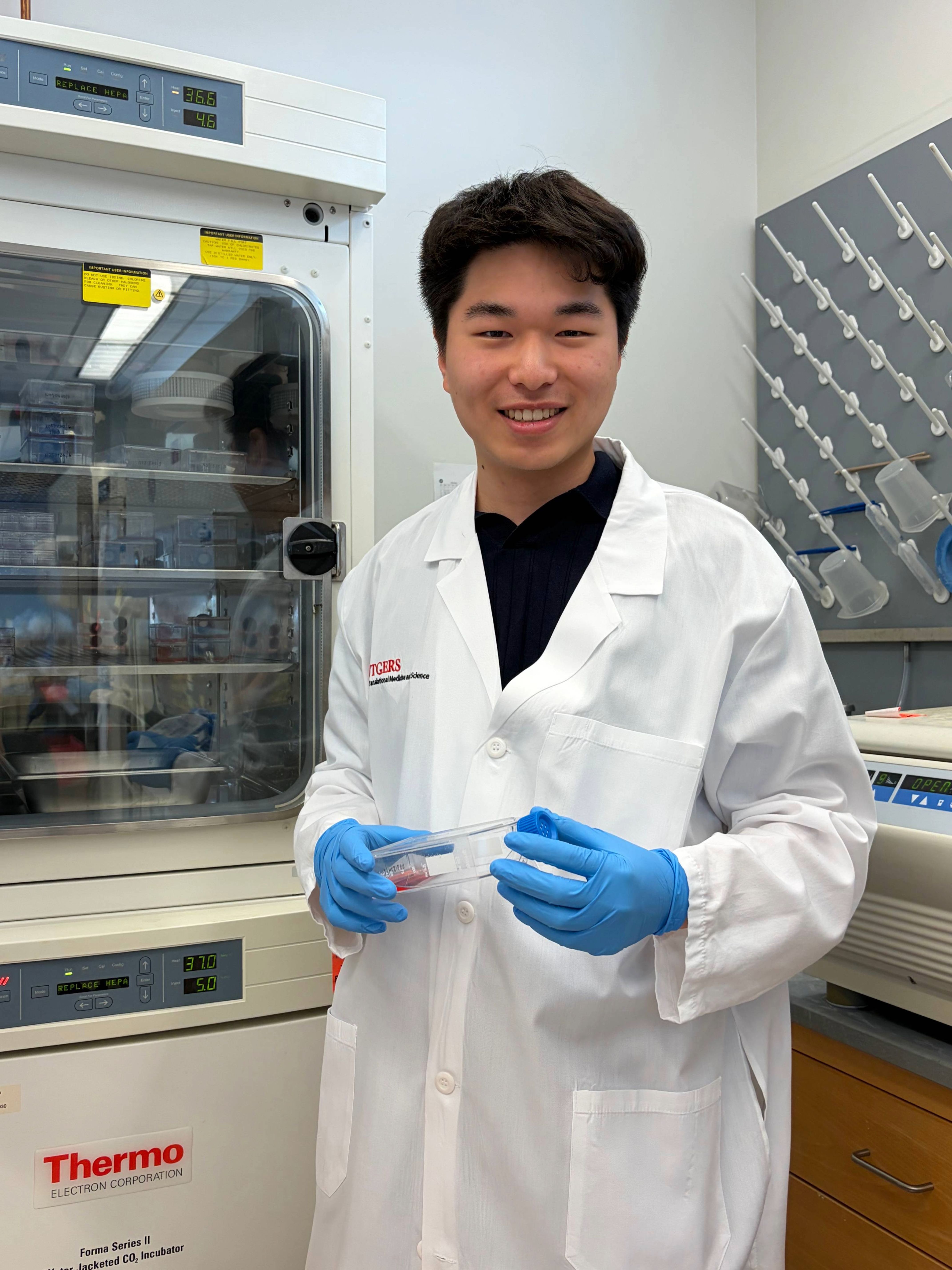 Brandon Jung smiling in a lab coat