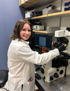 Hailey Graff at the microscope, smiling