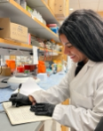 Monica Hanna at lab bench smiling