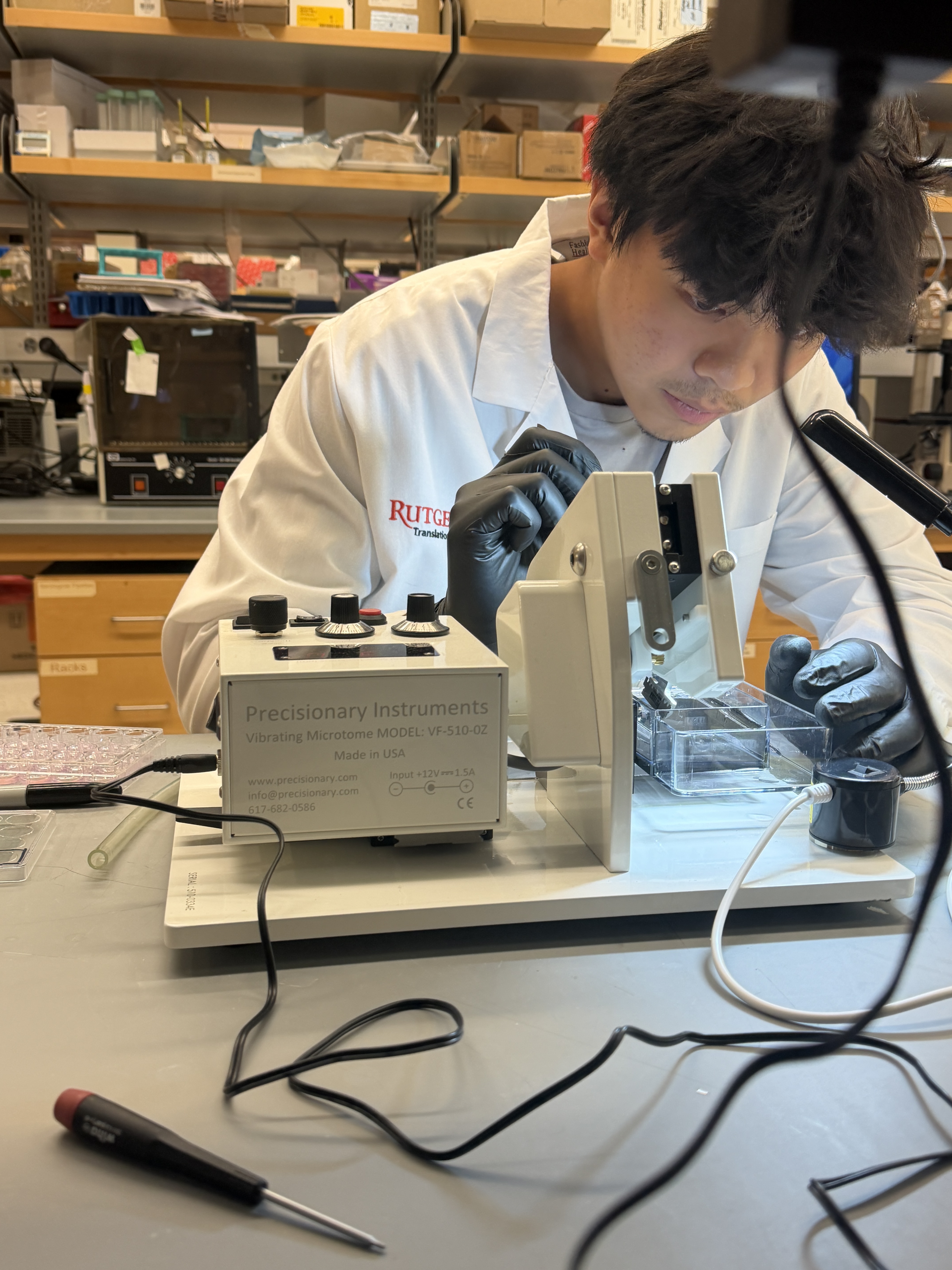 Tristan Li in a lab coat at a microscope